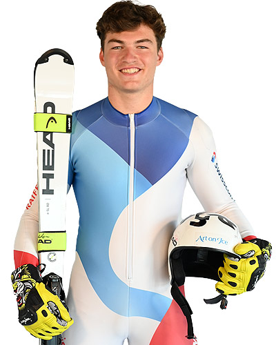Alessio Miggiano, Swiss skier, in racing suit and with skis in hand