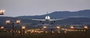 Airplane (Swiss) about to land at Zurich airport in the middle of lots of runway lights.
